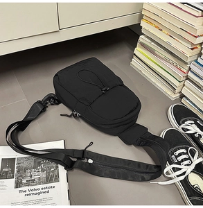 Detail of black nylon chest bag with drawstring pocket and utility strap pocket