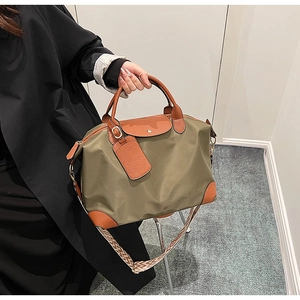 Detail of olive nylon travel tote with leather trim and textured woven shoulder strap