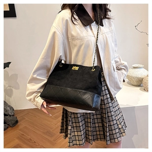 Detail of vintage black suede and quilted leather tote with gold chain strap