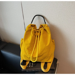 Dettaglio dello zaino giallo in nylon con coulisse e tessuto resistente all'acqua