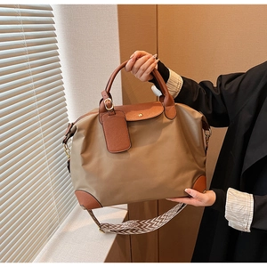 Close-up of waterproof nylon tote bag with leather handles and geometric strap