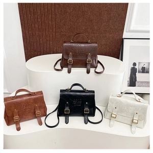 Detail view of four vintage leather backpacks in coffee, caramel, black and white tones