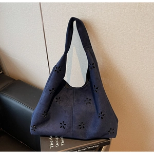 Detail of dark blue hollow-out laser-cut floral pattern on casual suede tote bag