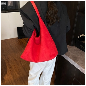 Detailed view of a red matte large capacity tote bag worn on shoulder in a cozy room