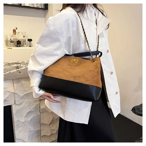 Detail of classic diamond quilted stitching on dual-tone suede and leather chain bag
