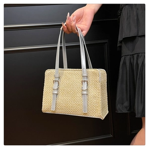 Detail of knit beige tote bag with silver patent leather straps and metal buckle accents