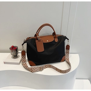 Detail of nylon tote bag with leather trim and wide geometric woven shoulder strap