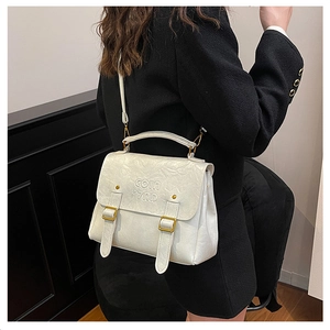 Detail of white leather handbag with adjustable buckles and COIN 7ND embossed logo