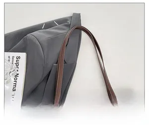 Detail of dark brown woven tote bag featuring smooth leather strap and metal buckle