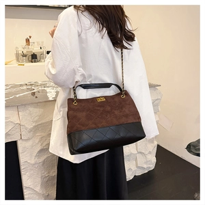 Detail of vintage suede tote bag showing bicolor quilted leather and gold chain strap