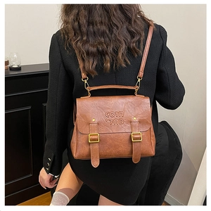 Brown vintage leather backpack featuring golden metal buckles and embossed texture detail