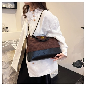 Close-up of vintage chain bag with brown suede and black leather patchwork design