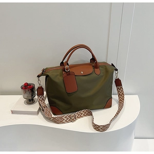 Detail of army green nylon tote bag with leather trim and geometric patterned shoulder strap
