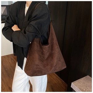 Macro detail of high-capacity dark brown suede tote bag with hobo bucket design