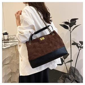 Detail of vintage quilted tote bag featuring gold twist lock and chain strap on suede finish