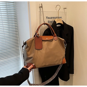 Detailed shot of nylon tote bag with leather trim and geometric patterned shoulder strap