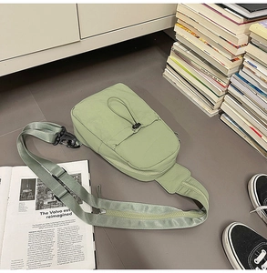 Detail of light green nylon sling bag with durable drawstring and metallic hooks
