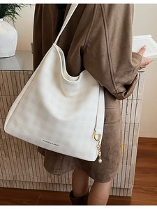 Borsa tote a scacchi con scritta 'FASHION & BAGS' e ciondolo di perle portata a spalla