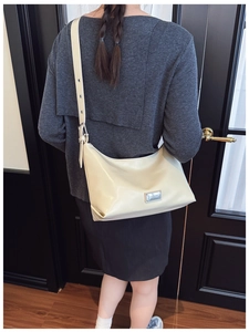 Detailed side view of off-white faux leather hobo bag with adjustable wide shoulder strap