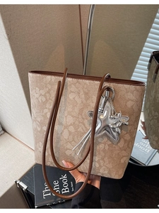 Floral print tote bag with brown leather handles and silver balloon dog charm