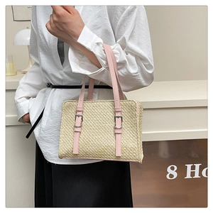 Detailed macro view of woven straw texture and soft pink leather strap on handbag