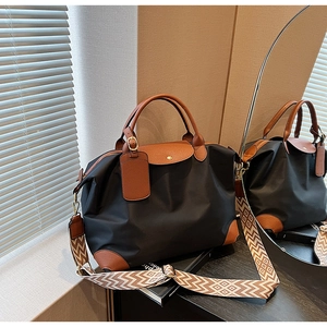 Detailed shot of nylon tote bag with leather trim and geometric patterned shoulder strap