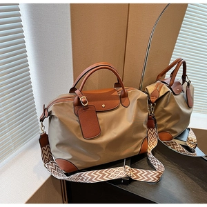 Detail view of khaki nylon Boston bag with leather trim and geometric pattern strap