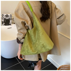 Detail of soft matte mustard green suede tote bag with wide shoulder strap on model