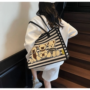 Détail du sac cabas en toile rayée avec broderie ours en peluche sur la bandoulière