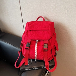 Minimalist red nylon backpack with dual buckle closure and drawstring for travel