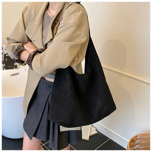Minimalist black oversized frosted leather tote bag shown on shoulder for daily commute