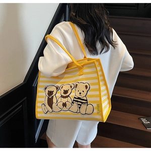 Gros plan détaillé du grand sac cabas en toile à rayures jaunes avec broderie ours en peluche