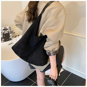 Minimalist black matte suede tote bag shown on shoulder for professional daily commute