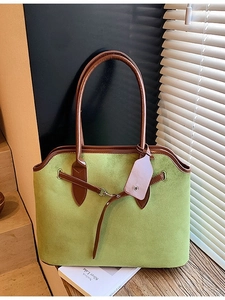 Retro green suede tote bag with brown leather trim on wooden stairs in natural light