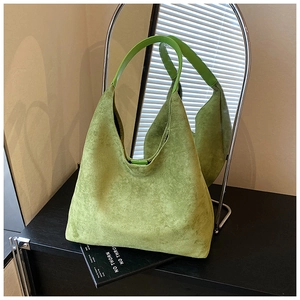 Detail view of large green suede hobo bag with smooth leather strap and fine stitching