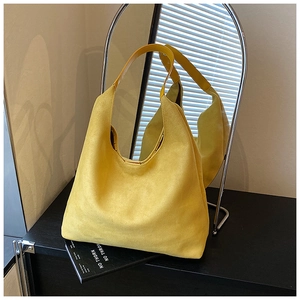 Close-up of a large yellow frosted suede tote bag showing soft texture and strap detail