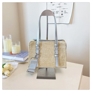 Detail of woven straw bag with adjustable nylon shoulder strap and metallic buckle