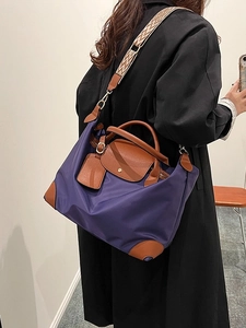 Purple nylon tote bag with leather handles and patterned strap shown on a model