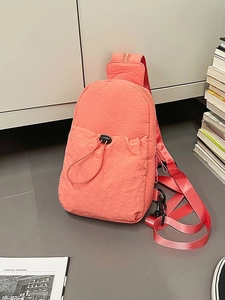 Versatile coral orange nylon chest bag with drawstring pocket and adjustable strap