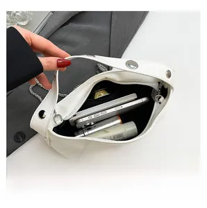 Internal capacity of the white studded bucket bag showing space for phone and skincare