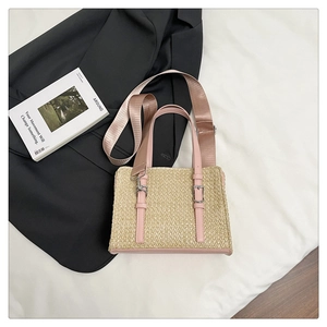 Straw patchwork crossbody bag with pink leather trim and a wide woven shoulder strap