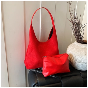 Detail of red suede hobo bag and matching leather pouch in minimalist style