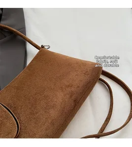 Detailed view of soft brown suede fabric and fine stitching on the minimalist shoulder bag