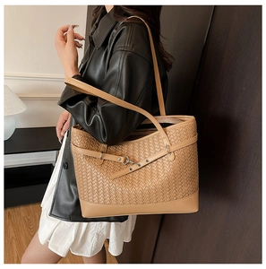 Detail showing the intricate woven texture and slim shoulder strap of the tan tote bag