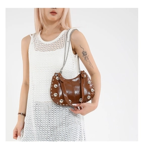 Detail of vintage brown leather bucket bag with silver studs and chain strap