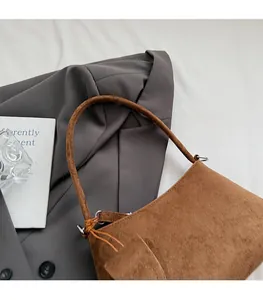 Detail of soft brown faux suede shoulder bag featuring a comfortable wide strap design