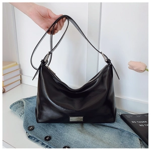 Detail view of the black glossy underarm bag featuring a silver zipper and metal logo