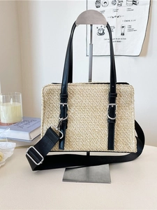 Woven straw beach tote bag with black handles and detachable shoulder strap in cream