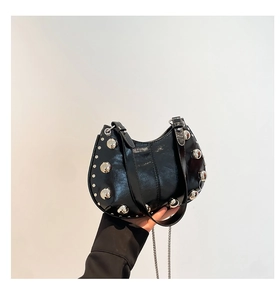 Détail du sac demi-lune en cuir noir avec rivets métalliques argentés et chaîne