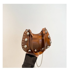 Gros plan du sac hobo en cuir poli marron avec rivets argentés et bandoulière chaîne